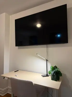 a desk with a television on a wall with a lamp at The Broadway Escape - Private Room in Times Square in New York