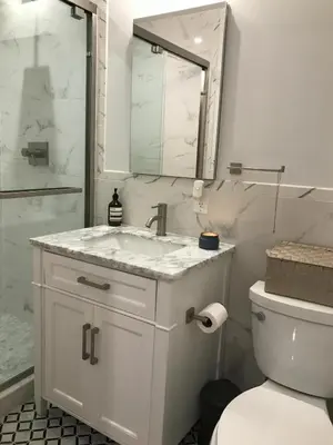 a white bathroom with a sink and a toilet at Cosy apartment in prime West Village in New York