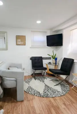 a living room with two chairs and a tv at Sunny Oak Lane Studio Near Einstein, LaSalle, Center City in Philadelphia