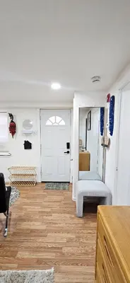 a living room with a white door and a wooden floor at Sunny Oak Lane Studio Near Einstein, LaSalle, Center City in Philadelphia