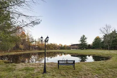 a park bench and a street light next to a pond at Family Staycation Retreat 7BDR Sauna Games