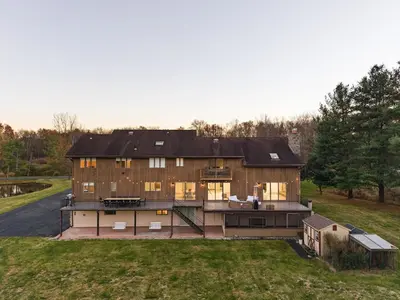 a large wooden house on a hill with a yard at Family Staycation Retreat 7BDR Sauna Games