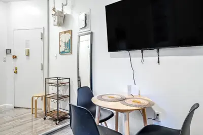 a living room with a table and chairs and a flat screen tv at The Black Bellvue NYC in New York