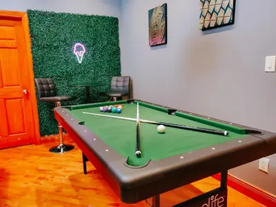 a pool table in a room with two chairs at IceCream - Pool Table - 120 Projector - King Bed in Philadelphia