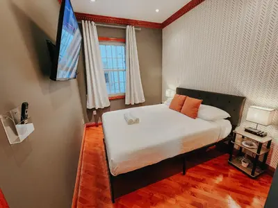 a bedroom with a bed and a tv on a wall at IceCream - Pool Table - 120 Projector - King Bed in Philadelphia