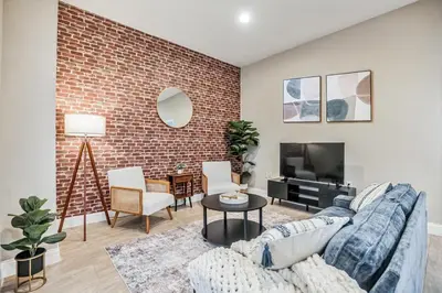 a living room with a couch and a brick wall at Luxury 3 Bedroom - Perfect Center City Location in Philadelphia