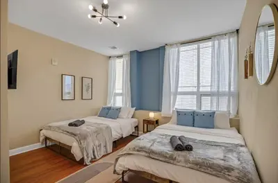 two beds in a room with two windows at Luxury 3 Bedroom - Perfect Center City Location in Philadelphia