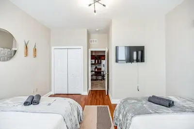 a bedroom with two beds and a tv on the wall at Luxury 3 Bedroom - Perfect Center City Location in Philadelphia