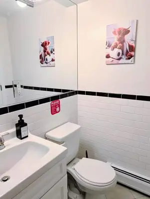a white bathroom with a toilet and a sink at Family-Friendly 2BR, NYC Access in Minutes in Hoboken