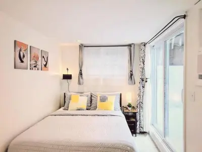 a bedroom with a bed and a large window at Family-Friendly 2BR, NYC Access in Minutes in Hoboken