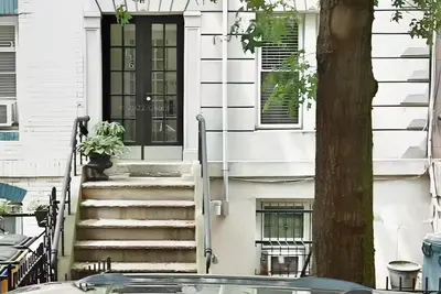 a front door of a white house with stairs at Family-Friendly 2BR, NYC Access in Minutes in Hoboken