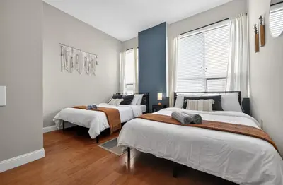 two beds in a bedroom with blue walls and wood floors at Luxury 3 Bedroom - Perfect Center City Location - 501 in Philadelphia