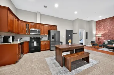 a large kitchen with wooden cabinets and a table at Luxury 3 Bedroom - Perfect Center City Location - 501 in Philadelphia