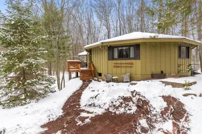 a yellow tiny house in the woods in the snow at Chic 2 BD 2 BA Near Skiing Fireplace etc in Pocono Pines