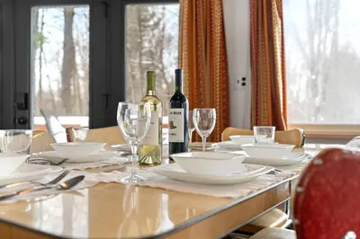 a dining table with a bottle of wine and glasses at Chic 2 BD 2 BA Near Skiing Fireplace etc in Pocono Pines