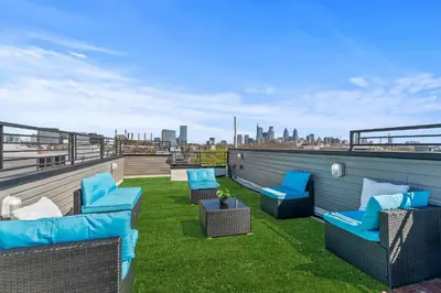 a patio with blue chairs on a roof at Skyline Escape in Philadelphia Chic & Bright in Philadelphia