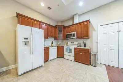 a kitchen with wooden cabinets and white appliances at Modern 2 bedroom - Center City Philadelphia in Philadelphia