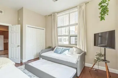 a living room with two beds and a tv at Modern 2 bedroom - Center City Philadelphia in Philadelphia