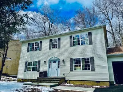 a white house with a blue door at Lakeview Family Retreat Newly Renovated 4BR House in Pocono Country Place