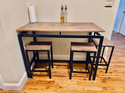a table with two stools and a table with bottles on it at Modern Luxury Executive Room with NYC Fast Access in Paterson