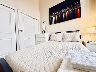 a bedroom with a bed and a painting on the wall at Modern Luxury Executive Room with NYC Fast Access in Paterson