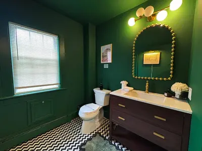 a green bathroom with a toilet and a mirror at 6000sf Luxe Estate Pond|Tennis|Sauna|Hottub|Movie in East Stroudsburg