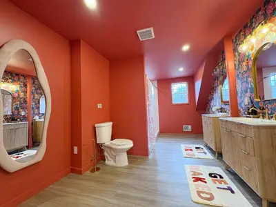 a bathroom with orange walls and a toilet and a mirror at 6000sf Luxe Estate Pond|Tennis|Sauna|Hottub|Movie in East Stroudsburg