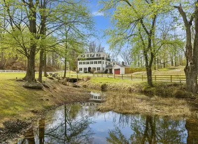 a house with a pond in front of it at 6000sf Luxe Estate Pond|Tennis|Sauna|Hottub|Movie in East Stroudsburg