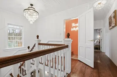 a white staircase in a home with a chandelier at 6000sf Luxe Estate Pond|Tennis|Sauna|Hottub|Movie in East Stroudsburg