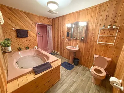 a bathroom with a tub and a toilet and a sink at 6bds|Secluded|Pool|Hot tub|Sauna|Games|Movie in Long Pond