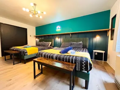 two beds in a room with a green wall at 6bds|Secluded|Pool|Hot tub|Sauna|Games|Movie in Long Pond