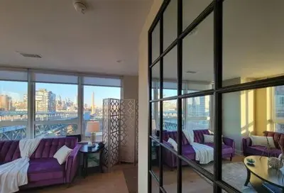 a living room with purple couches and a view of a city at Stay Like A Boss- Penthouse-Views- Convention Center- Free Parking in Philadelphia