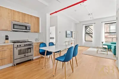 a kitchen and dining room with a table and blue chairs at 517 -41D Gorgeous and Fully Equipped Luxury 1 Bedroom Apt in New York