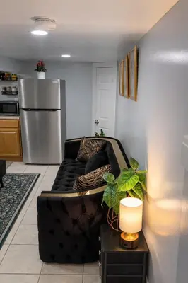 a living room with a black couch and a refrigerator at Modern Newark 1BR Apartment, Near Penn Station and EWR in Newark