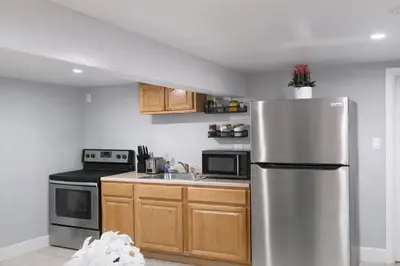 a kitchen with a stainless steel refrigerator and a sink at Modern Newark 1BR Apartment, Near Penn Station and EWR in Newark