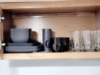 a shelf with plates and glasses in a cabinet at Modern Newark 1BR Apartment, Near Penn Station and EWR in Newark