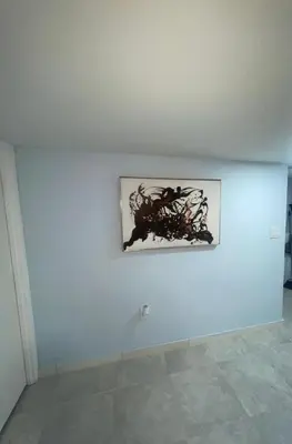 a painting on a blue wall in a room at Cozy Home 422 South 16th street in Newark