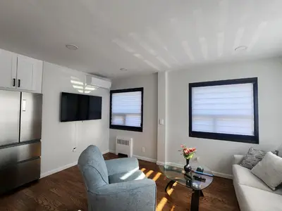 a living room with a couch and a table at Luxury Floral Loft with Balcony Near MetLife & NYC in Bogota