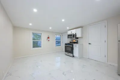 a white kitchen with a stove and a microwave at Modern 3BR - Train Station & Downtown 2 mins walk in Rahway