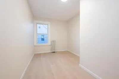 an empty room with a window and a radiator at Modern 3BR - Train Station & Downtown 2 mins walk in Rahway