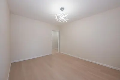 an empty living room with a chandelier and wood floors at Modern 3BR - Train Station & Downtown 2 mins walk in Rahway