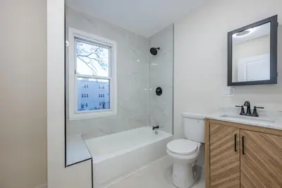 a bathroom with a tub and a toilet and a sink at Modern 3BR - Train Station & Downtown 2 mins walk in Rahway
