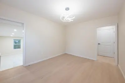 an empty living room with white walls and wood floors at Modern 3BR - Train Station & Downtown 2 mins walk in Rahway