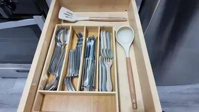 a wooden drawer with utensils in a box at A Luxury Apartment in the Heart of Hoboken in Hoboken
