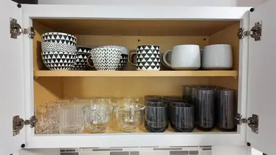 a cupboard filled with lots of glasses and plates at A Luxury Apartment in the Heart of Hoboken in Hoboken