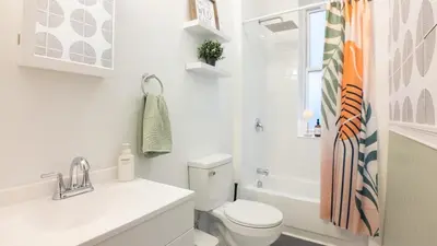 a white bathroom with a toilet and a sink at A Luxury Apartment in the Heart of Hoboken in Hoboken
