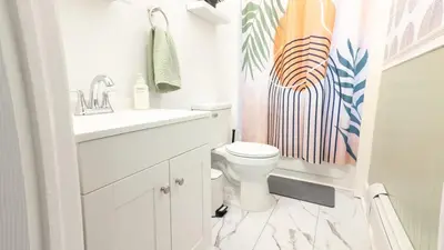 a white bathroom with a sink and a toilet at A Luxury Apartment in the Heart of Hoboken in Hoboken