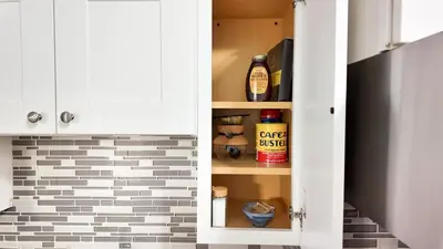 a cupboard in a kitchen with a brick wall at A Luxury Apartment in the Heart of Hoboken in Hoboken