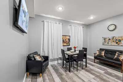 a dining room and living room with a table and chairs at Elegant 1BR Stay Near Zoo & Downtown Philly in Philadelphia