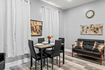 a dining room with a table and chairs and a couch at Elegant 1BR Stay Near Zoo & Downtown Philly in Philadelphia